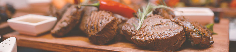 A row of cooked meat on a chopping board