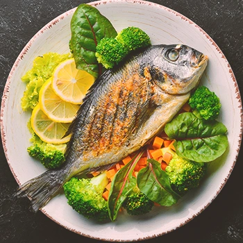 Cooked fish on a plate with garnish