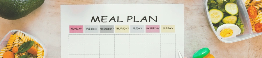 A clipboard with Meal Plan written with food on the sides