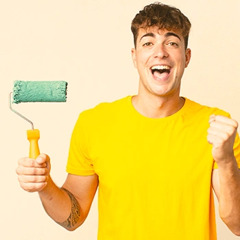 A happy man holding a paint roller