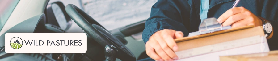 Someone signing a package inside a car with the WIld Pastures logo