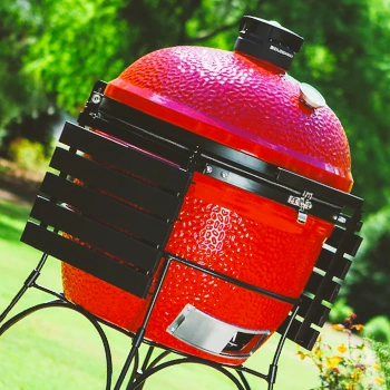 A red cylindrical grill out in the backyard