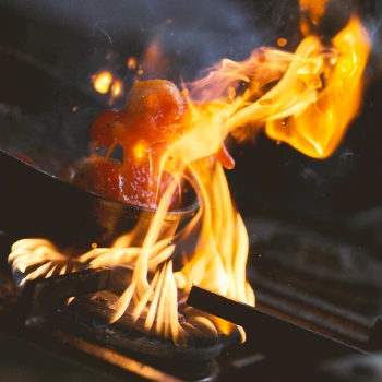 Close up shot of steak being cooked on high flame