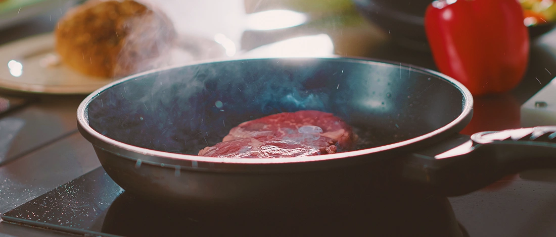 A steak being cooked on a pan