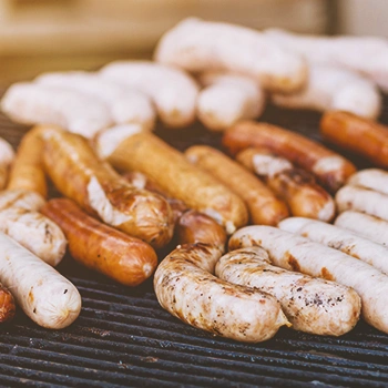 A variety of sausages being grilled