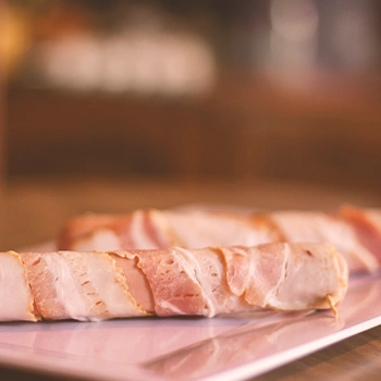 Bacon wrapped sausage on a tray