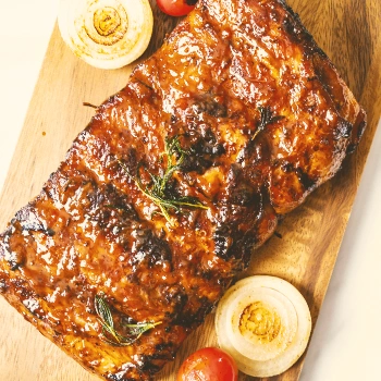 Top view of cooked pork ribs on a wooden board