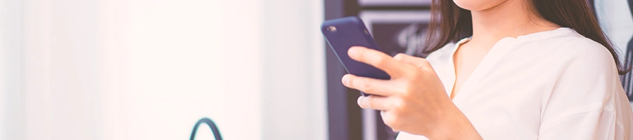 A woman holding her phone in the kitchen