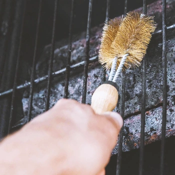 A person scrubbing a grill