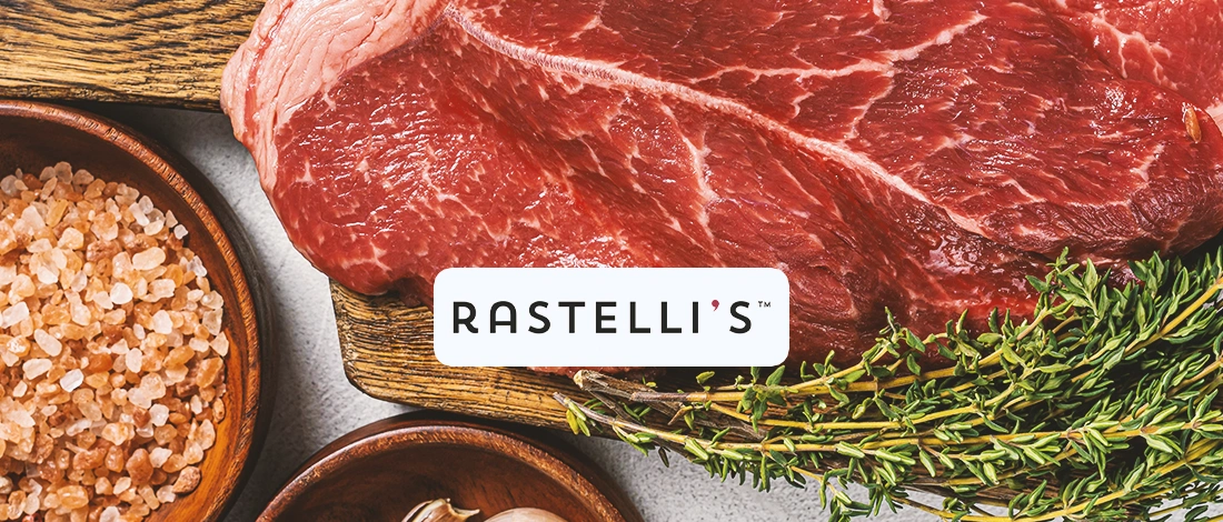 Close up shot of meat with herbs with the Rastelli's Logo