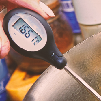 A person holding a digital thermometer