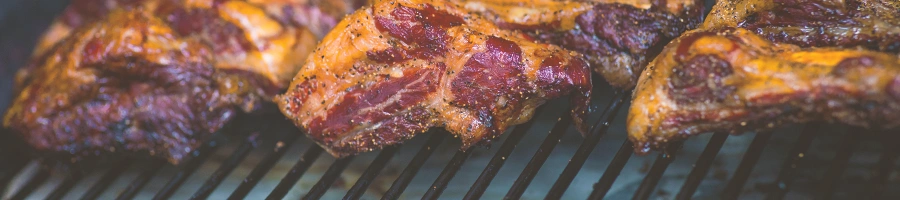 Raw meat being cooked on a grill