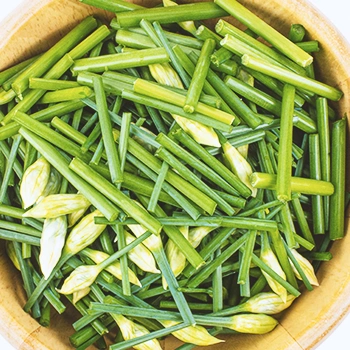 Chopped up green onion in a wooden bowl