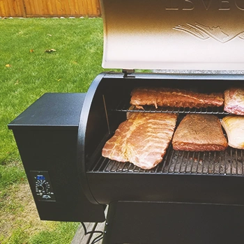 An open smoker with meat inside