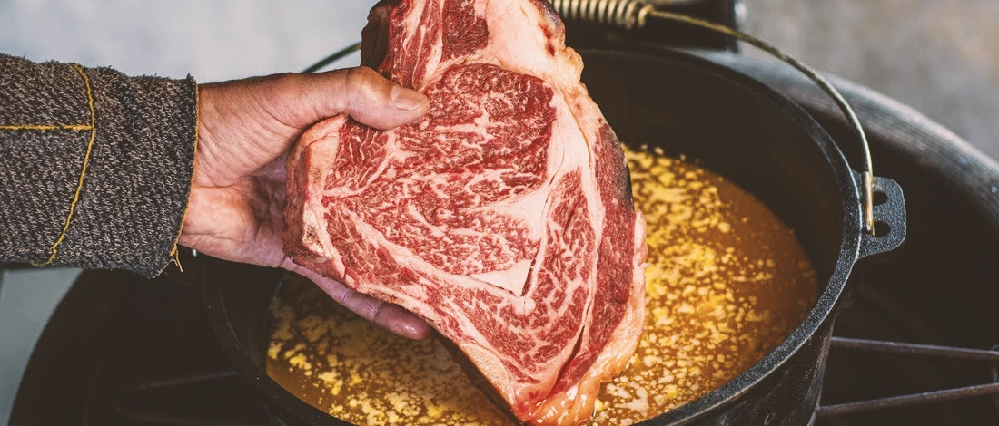 Steak being cooked in a lot of butter