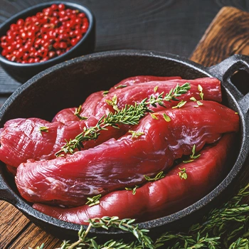 A stack of venison meat on a black pan