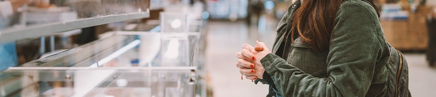 A customer looking for meat inside a supermarket