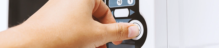 A person pressing on a microwave