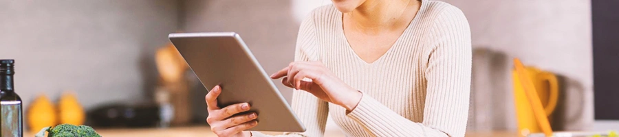 A person looking at her tablet in a kitchen