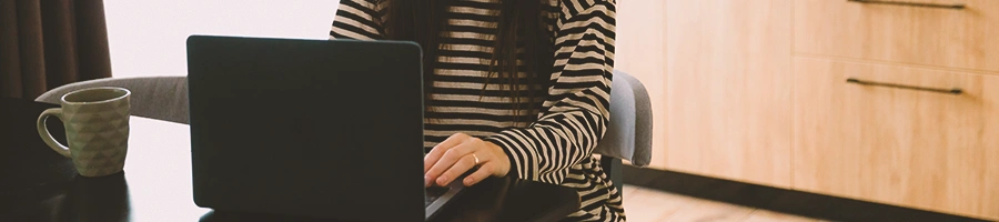 A person on her laptop in the kitchen