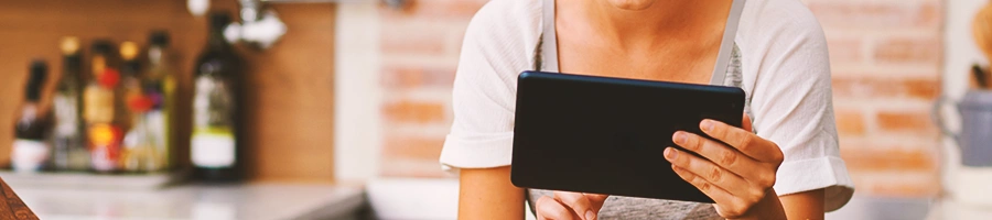 A person looking at her tablet in the kitchen