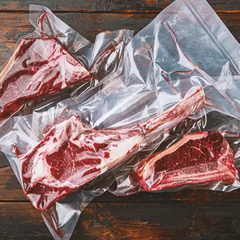 Vacuum sealed meat on a wooden table