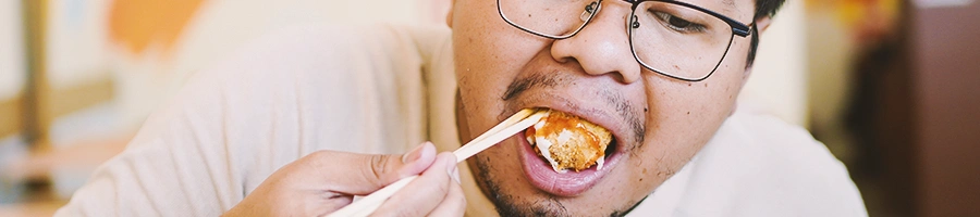 A person eating with chop sticks
