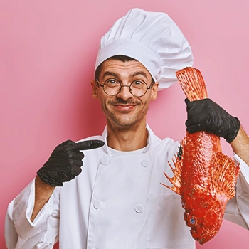 A chef holding up a fish