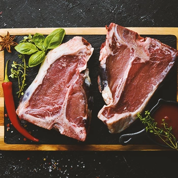 Two pieces of raw meat on a black plate