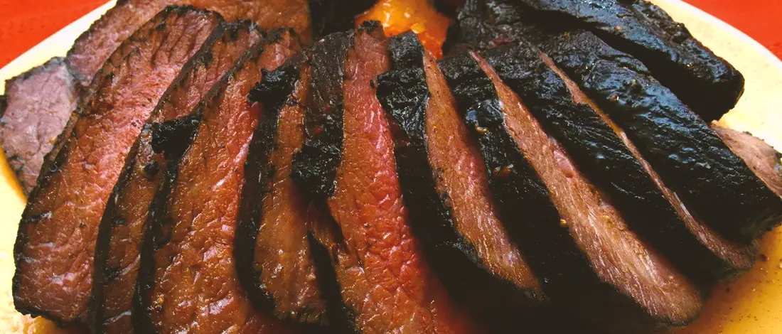 Dark charred meat on a plate