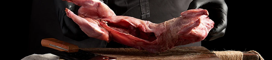 Butcher man-handling a rabbit meat