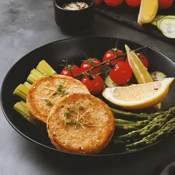 Salmon patties on a black bowl with garnish