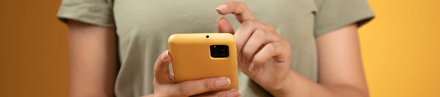 A person using a yellow mobile phone