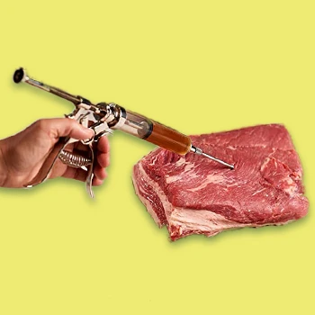 A picture of a hand using meat injector