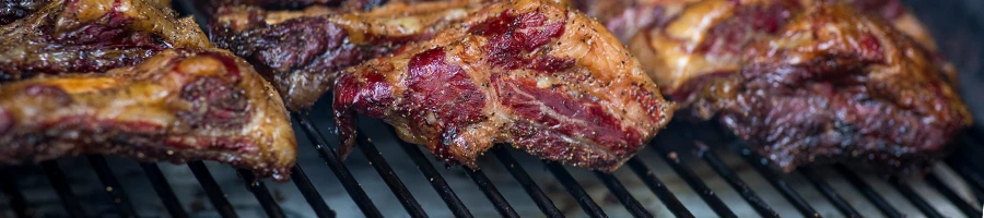 A close up image of meats inside a smoker
