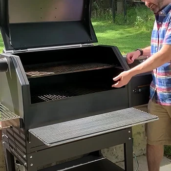 A person showing the inside of a smoker grill