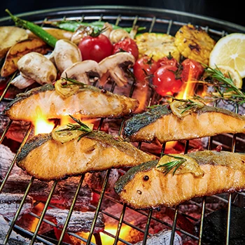 Fish on a grill with fruits and vegetables