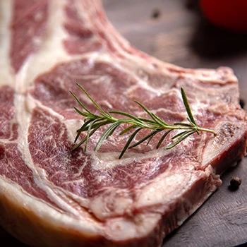 A close up image of a slice of meat with rosemary on top