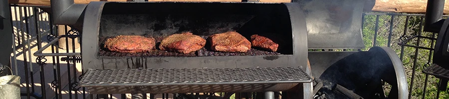 An offset smoker with meats inside