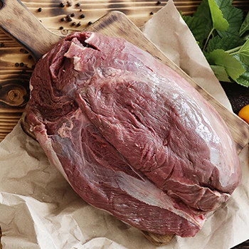 A dark colored meat on top of a cutting board