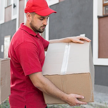 A delivery guy lifting a box wearing a red outfit