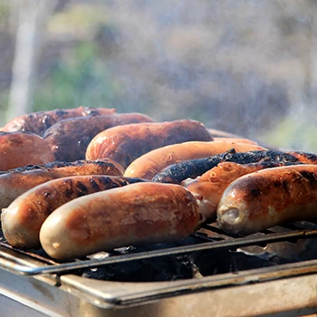 An image of sausages being grilled