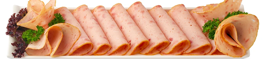 Slices of ham on a white plate and background