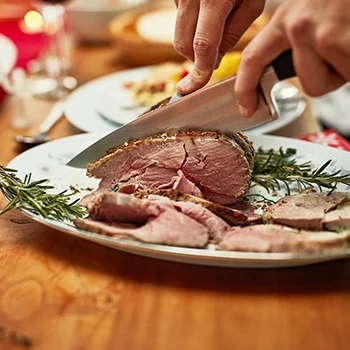 A person slicing a steak on a plate