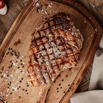 A grilled ribeye steak on a cutting board