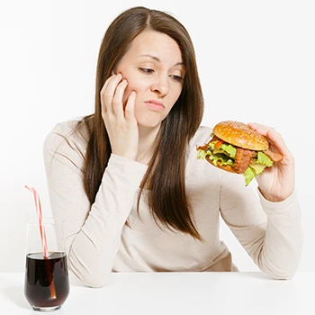 A woman looking at a burger