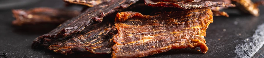 An image of beef jerky on a black slate