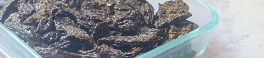 A close up image of beef liver crisps in a glass container