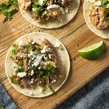 An image of carnitas on a wooden board