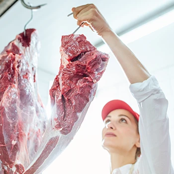 A woman holding a hooked meat